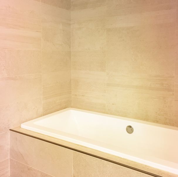 Large-format ceramic tiling around a built-in bath